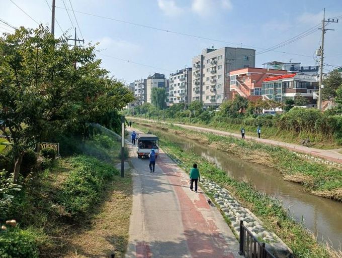 수원시 권선구보건소 관계자가 수원천변 산책로를 방역소독하고 있다.