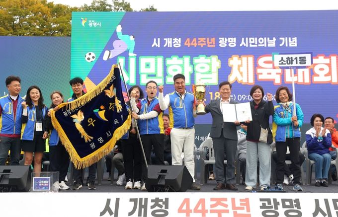 박승원 광명시장(사진 오른쪽에서 세 번째)이 지난 18일 광명시민체육관 잔디광장에서 열린 시민화합체육대회에서 종합 우승을 차지한 소하1동에 시상 후 기념사진을 촬영하고 있다.