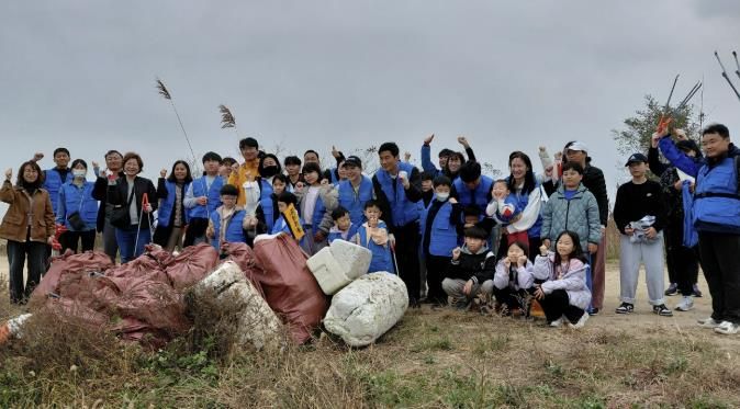 8일 화성시 가족봉사단과 함께하는 자원순환실천 연안정비활동 참가자들이 쓰레기 줍기 활동을 마치고 기념 촬영하고 있다